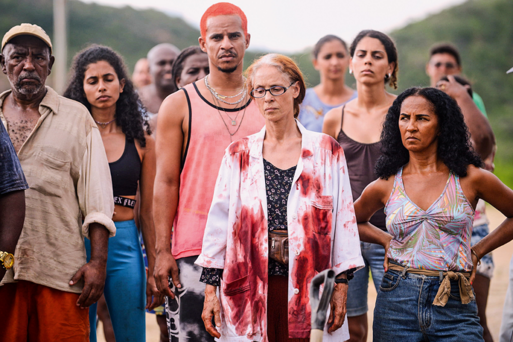 Grupo de pessoas com roupas simples, e no centro uma mulher com um jaleco branco sujo de sangue