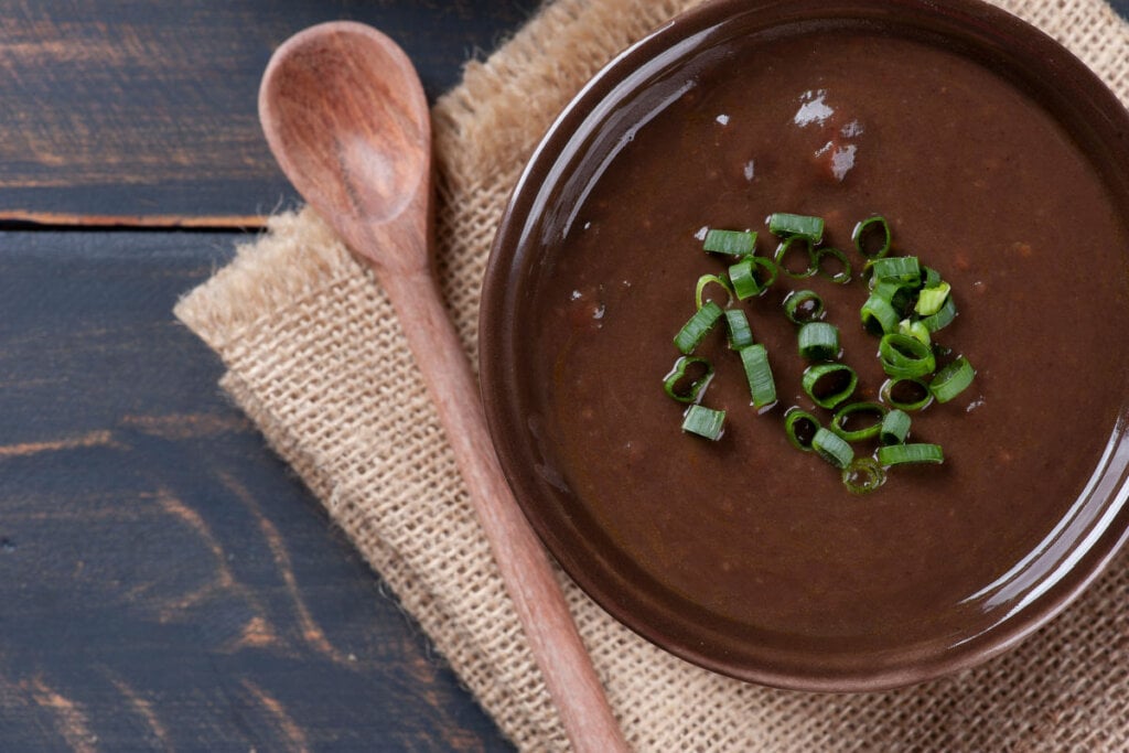 Recipiente de vidro marrom com caldo de feijão-preto
