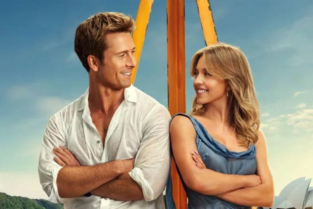 homem e mulher, um olhando para o outro e sorrindo. Os dois estão com os ombros encostados