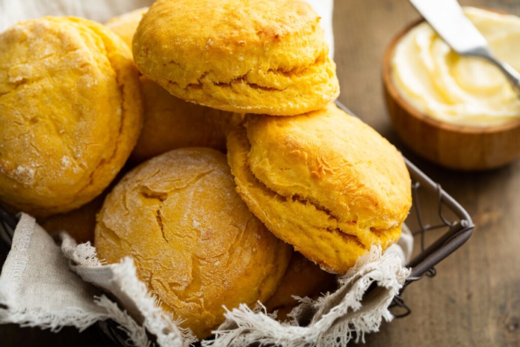 Biscoitos de batata-doce empilhados em uma cesta de metal forrada com pano branco