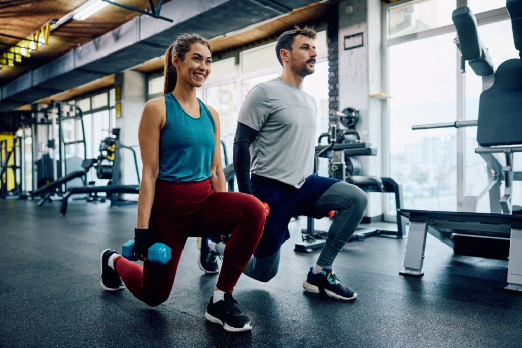 Casal usando roupas de academia treinando com peso