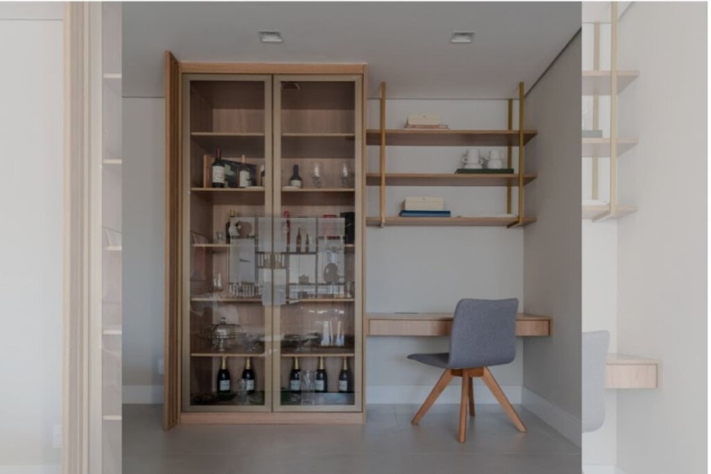 imagem de home office com armário e prateleira de madeira clara e cadeira cinza