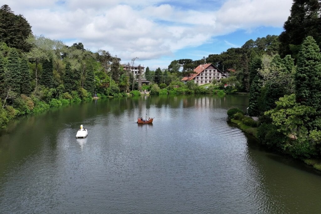 Vista do Lago Negro, rodeado por árvores e casas com arquitetura europeia em Gramado, RS
