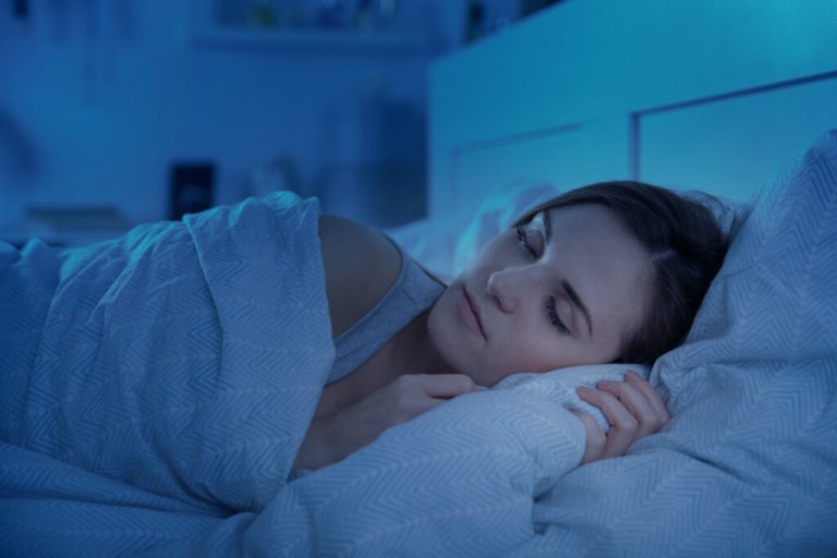 Mulher dormindo em cama com travesseiro e cobertor