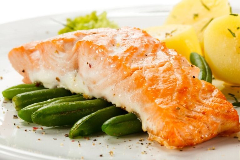 Filé de salmão em um prato sobre vagem e, ao lado, pedaços de batata 