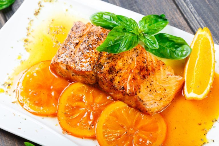 Salmão com molho de laranja e mel em prato decorado