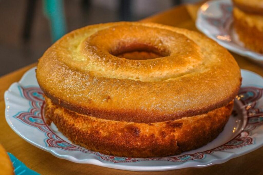 bolo de fubá redondo em cima de um prato branco