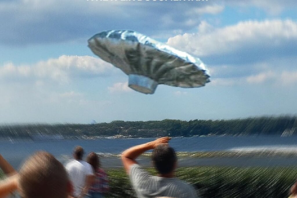 Pessoas observando um balão prateado em forma de disco voador flutuando no céu