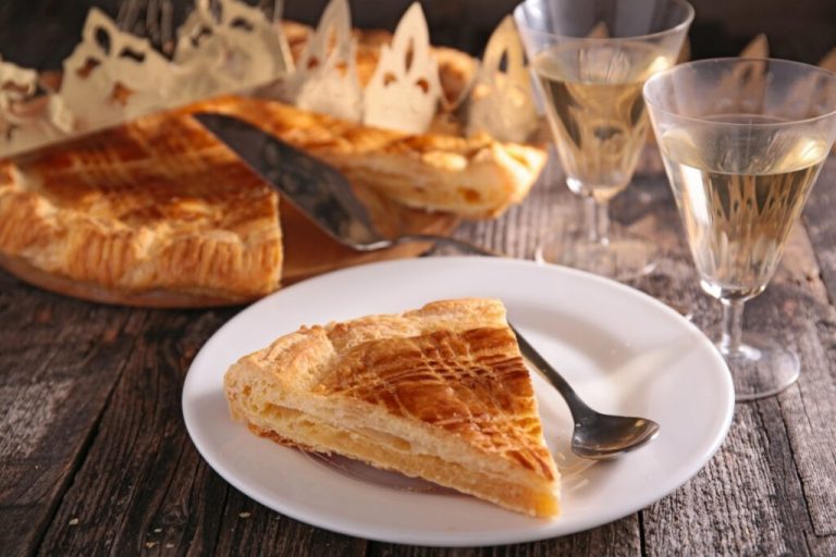 Galette des Rois em prato branco em cima de mesa de madeira