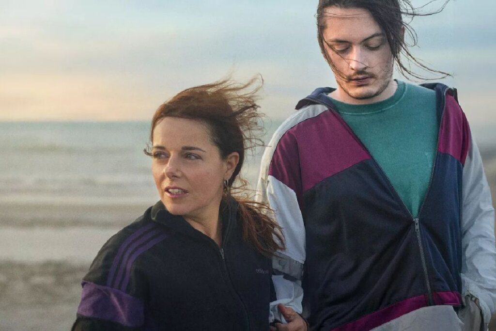 Homem e mulher olhando para o lado e em frente ao oceano em cena do filme " Pedaço De Mim"