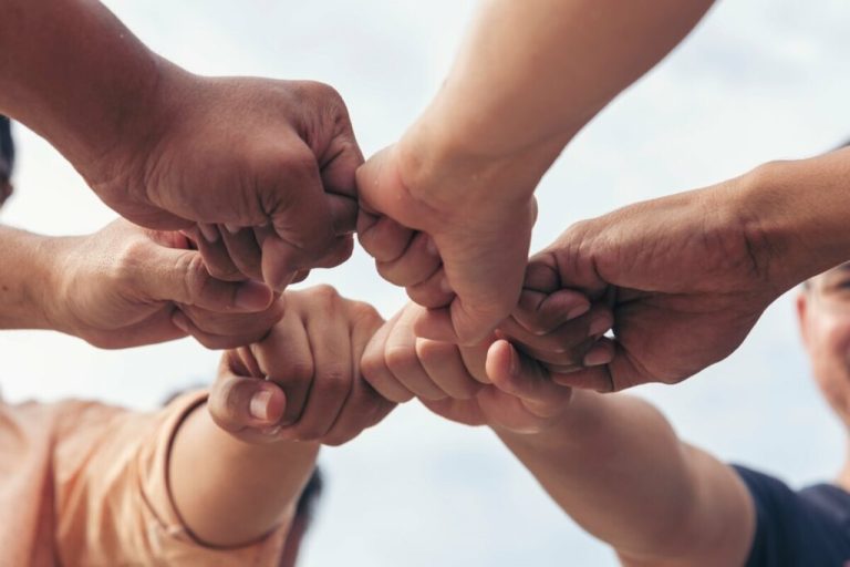 Mãos em punhos unidas em um círculo 