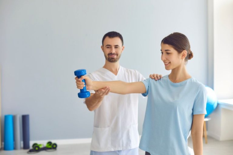 Mulher jovem fazendo exercício com haltere leve sob orientação de um profissional de saúde