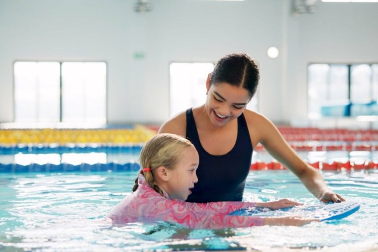 mulher de maiô preto e menina de camiseta rosa na piscina