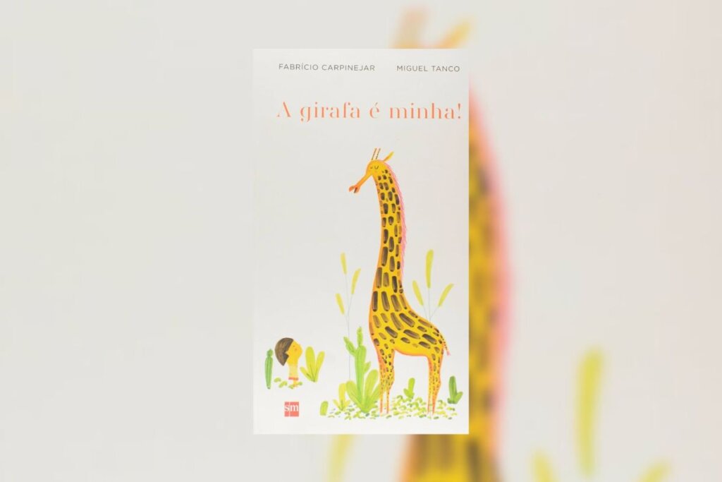 Capa do livro "A Girafa é Minha!" coma ilustração de uma criança e uma girafa em um jardim