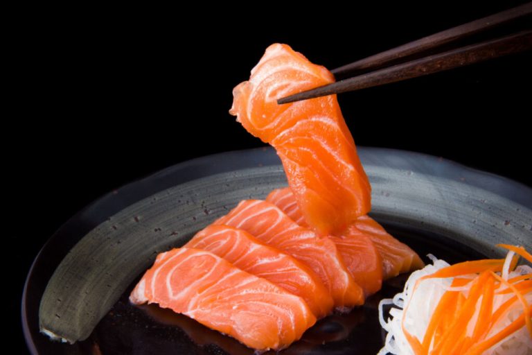 Sashimi de salmão suspenso por hashis